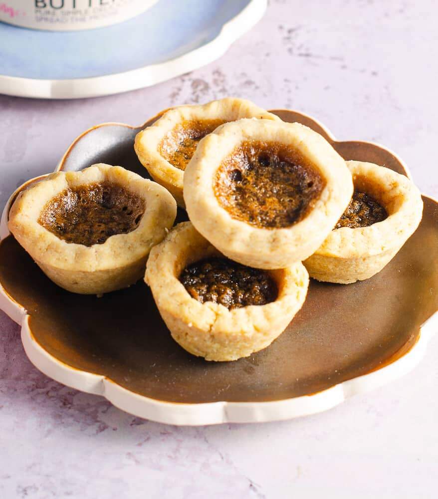 A plate of small bite sized tarts filled with a baked butter mixture