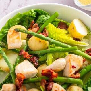 a bright white bowl of a warm bacon, asparagus, new potato and chicken salad