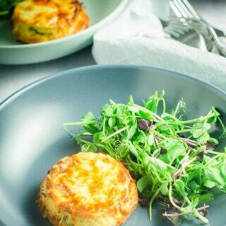 A table setting of 3 plates serving twice baked cheese souffles with side green salad.