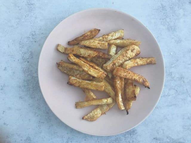 A plate of celeriac chips roasted with paprika on a blue toned backdrop by A Strong Coffee