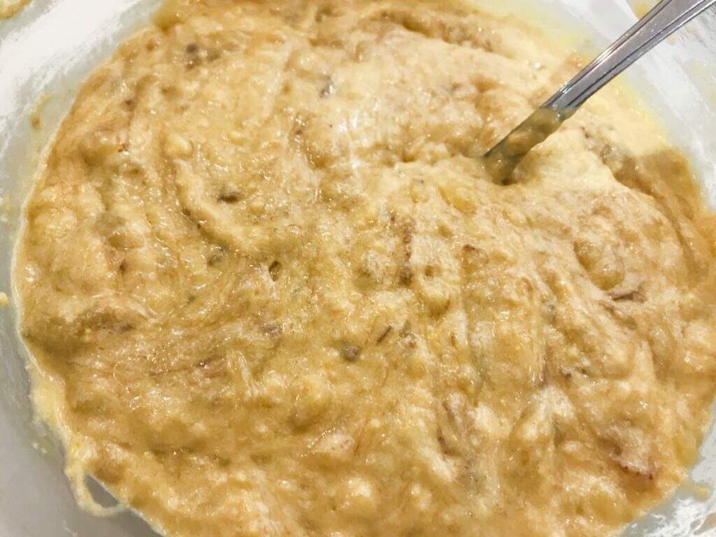 Banana bread batter, lightly mixed with all ingredients ready to be poured into a baking tin.
