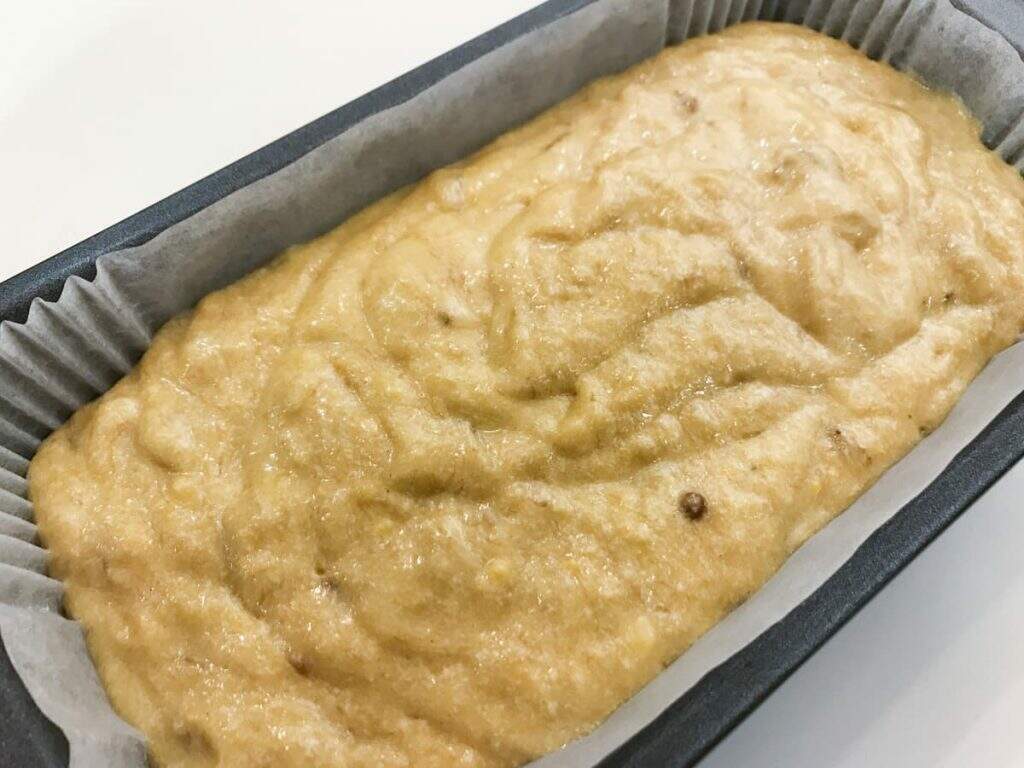 Banana loaf or bread batter poured into a loaf tin ready to be placed into the oven to bake.