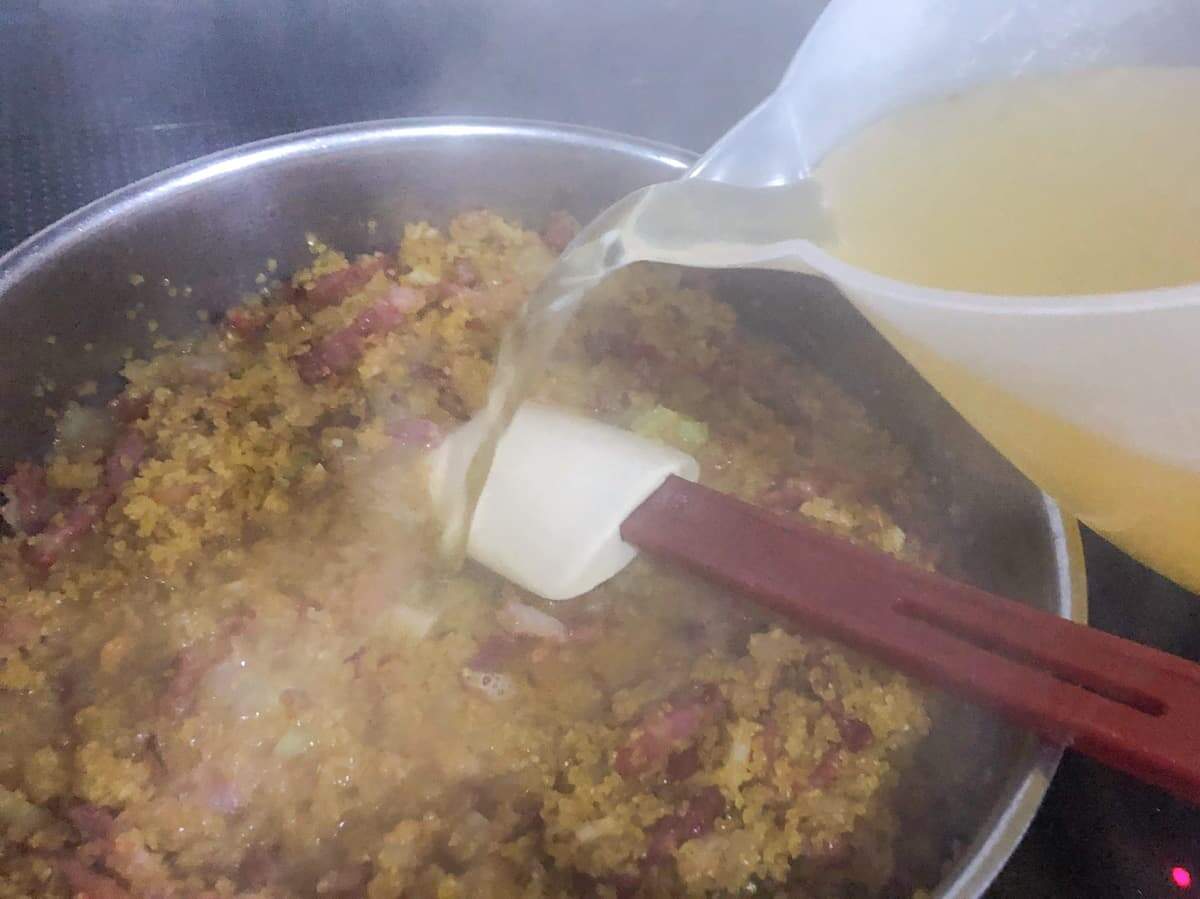 Adding stock to a bulgar wheat risotto.