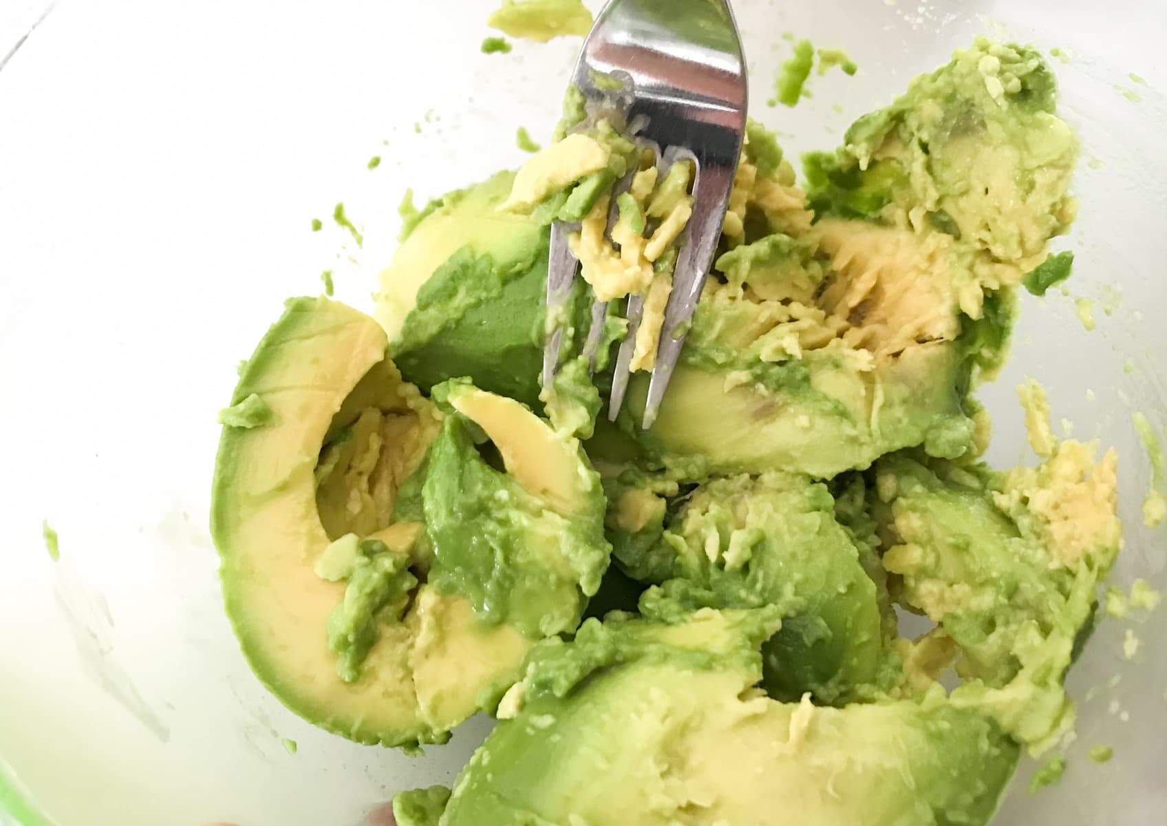 Smashing up avocado to be used in guacamole.