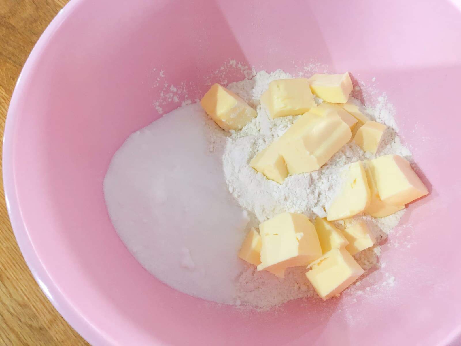 Step by step of making rhubarb crumble rubbing together flour, sugar and butter.