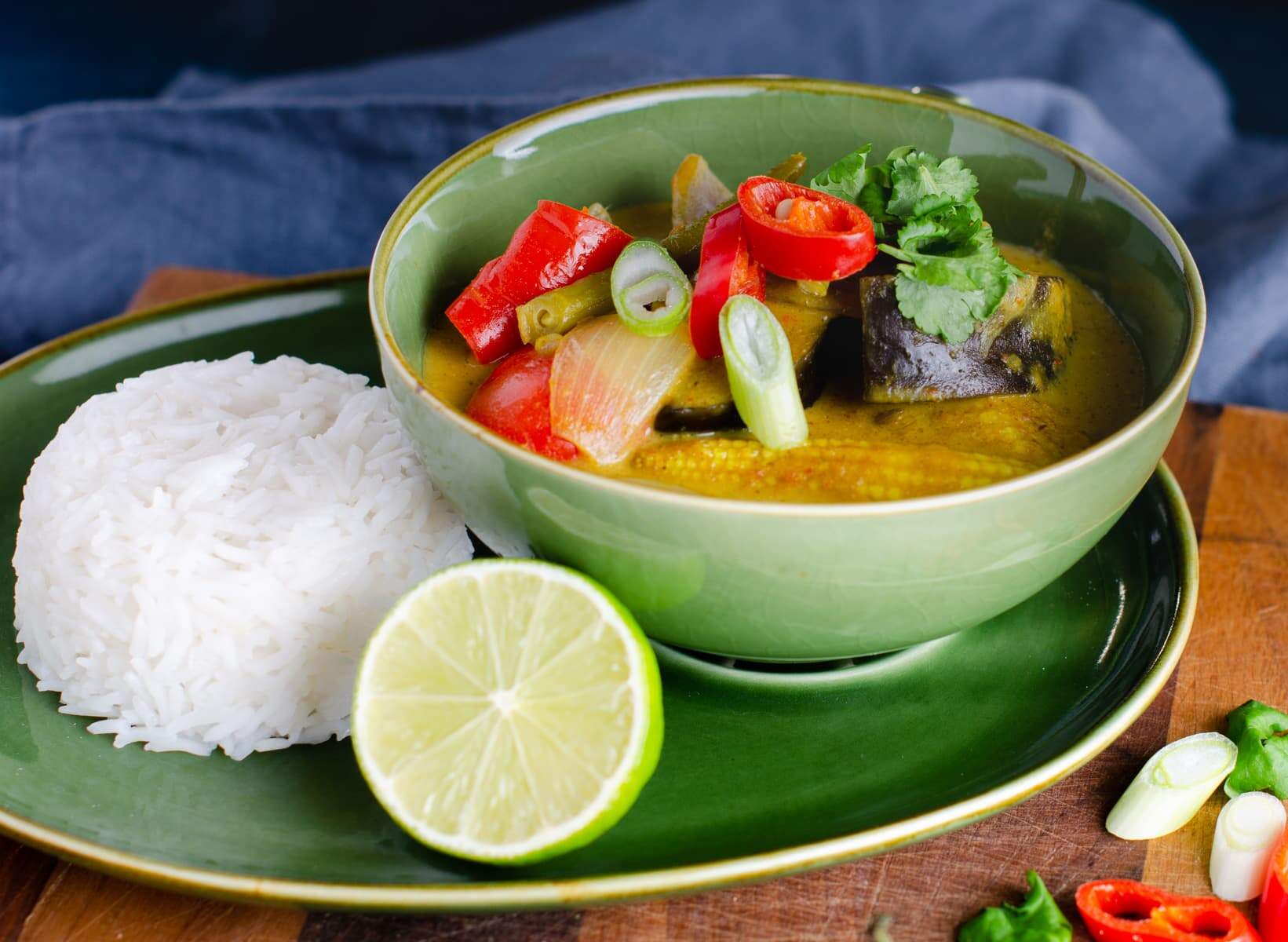 Vegetable and coconut curry served with rice and limes.