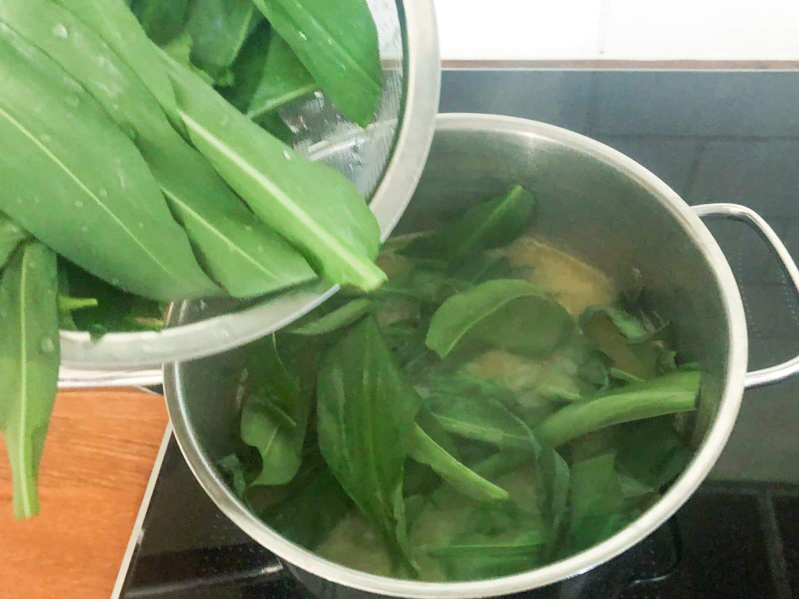 Wild garlic being added to a pot to make soup