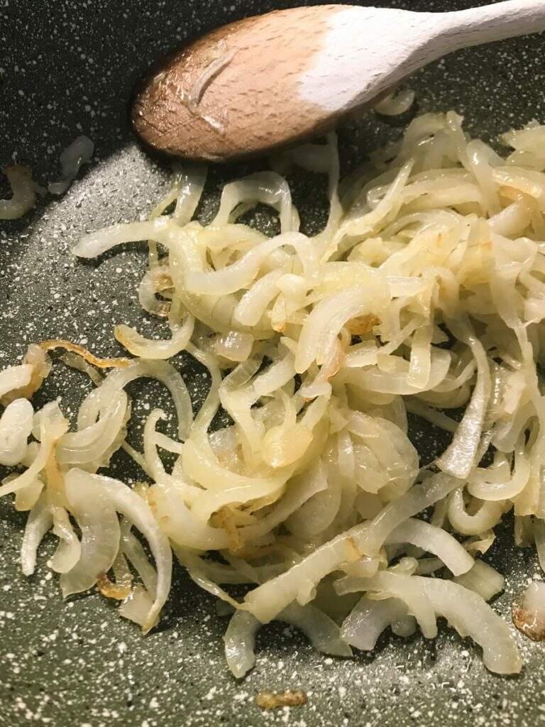 Sliced onions softened and just turning golden in a fry pan.