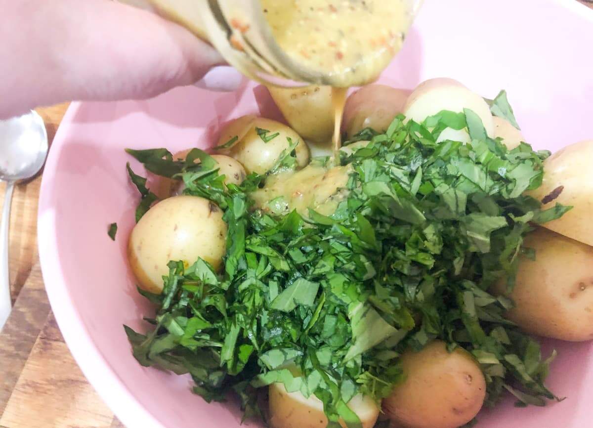 adding a vinaigrette dressing to warm potatoes and fresh chopped parsley and wild garlic to finish off a salad.