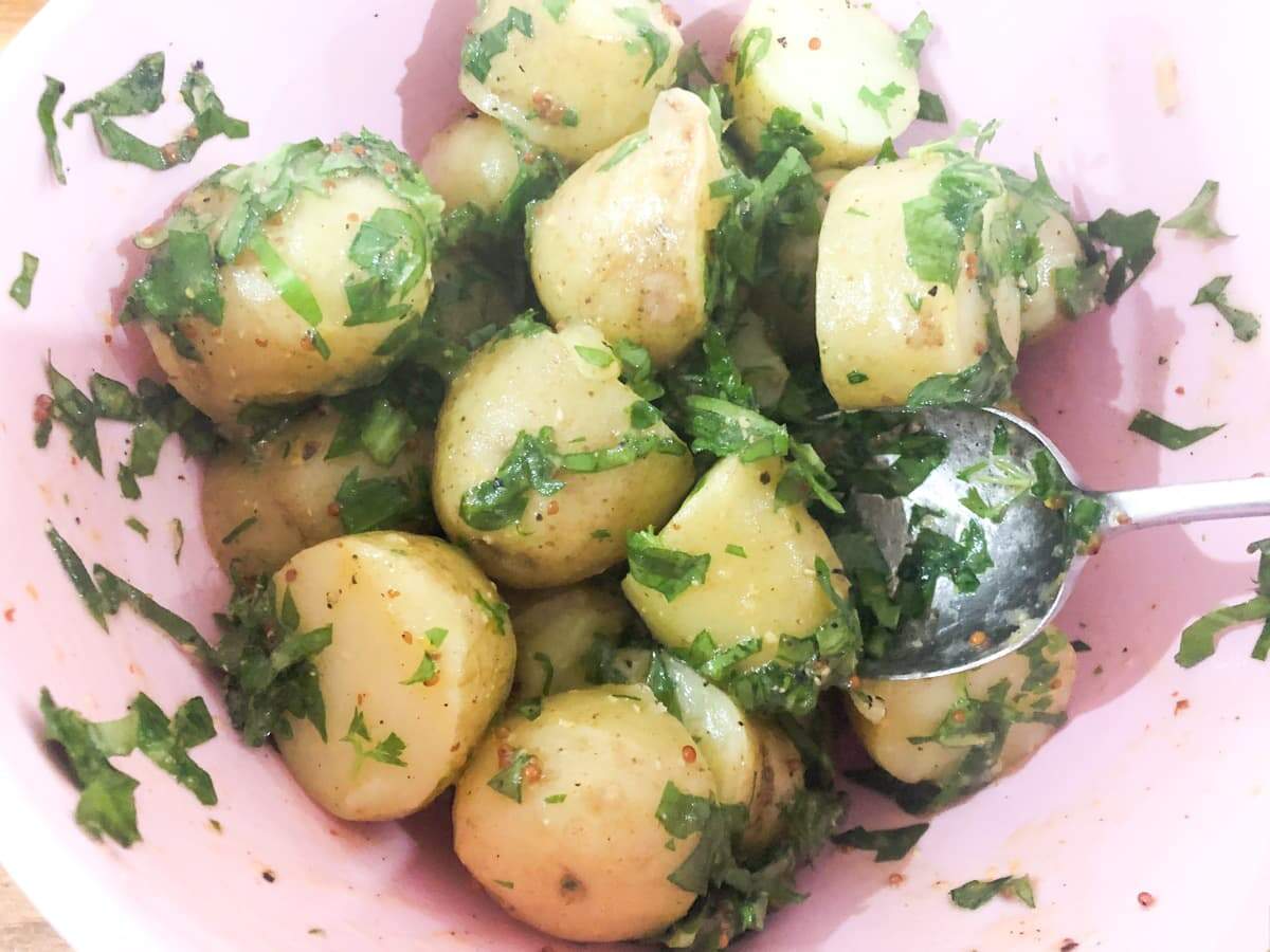 Warm potatoes tossed with a dressing and fresh chopped parsley and wild garlic.