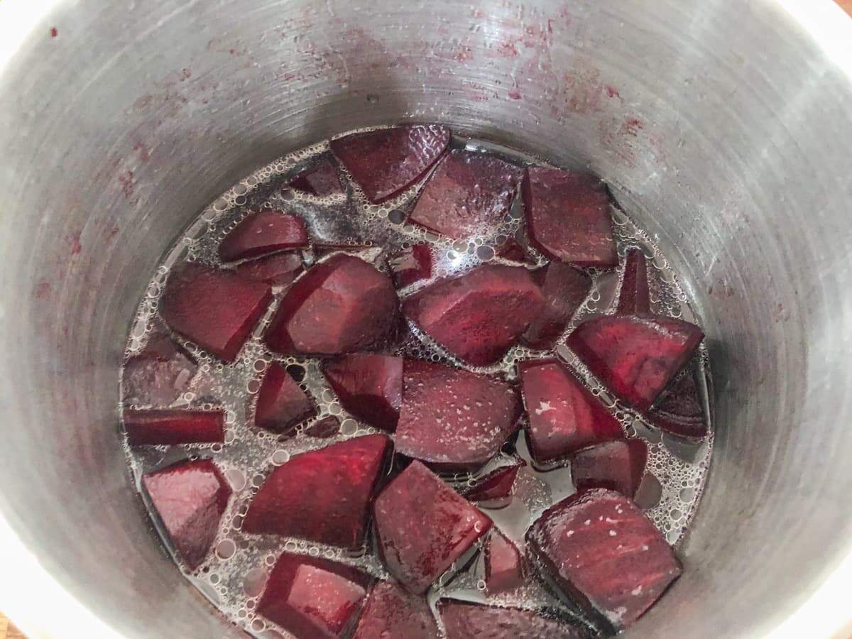 Chopped beetroot cooking in a pan of water.