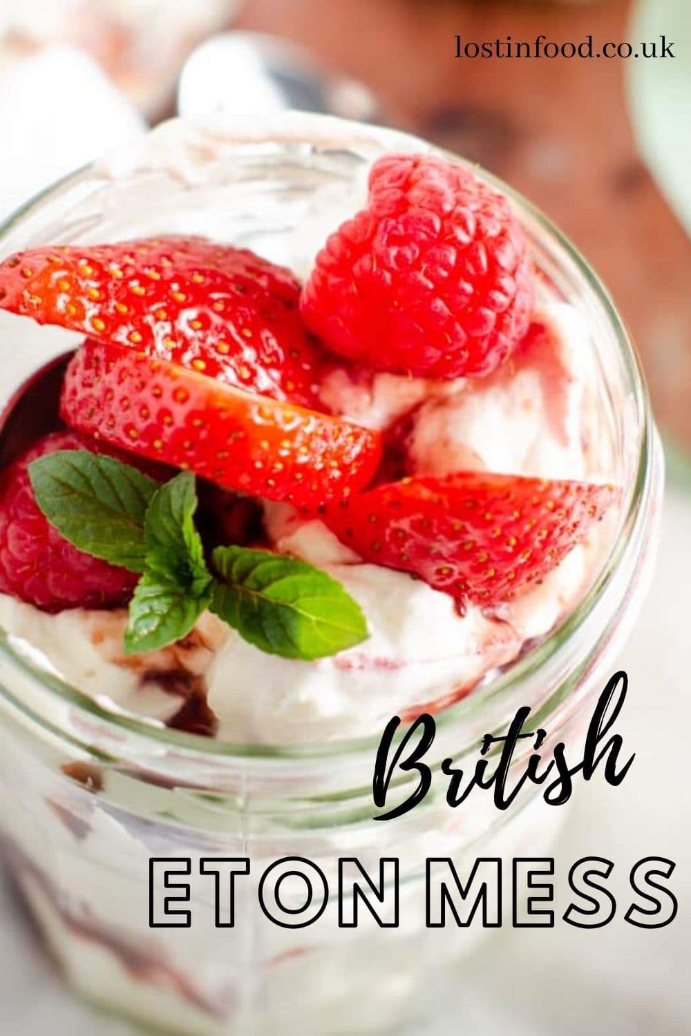 A jam jar filled with Eton Mess and topped with fresh strawberries and raspberries and a sprig of mint and a text overlay that reads British Eton Mess