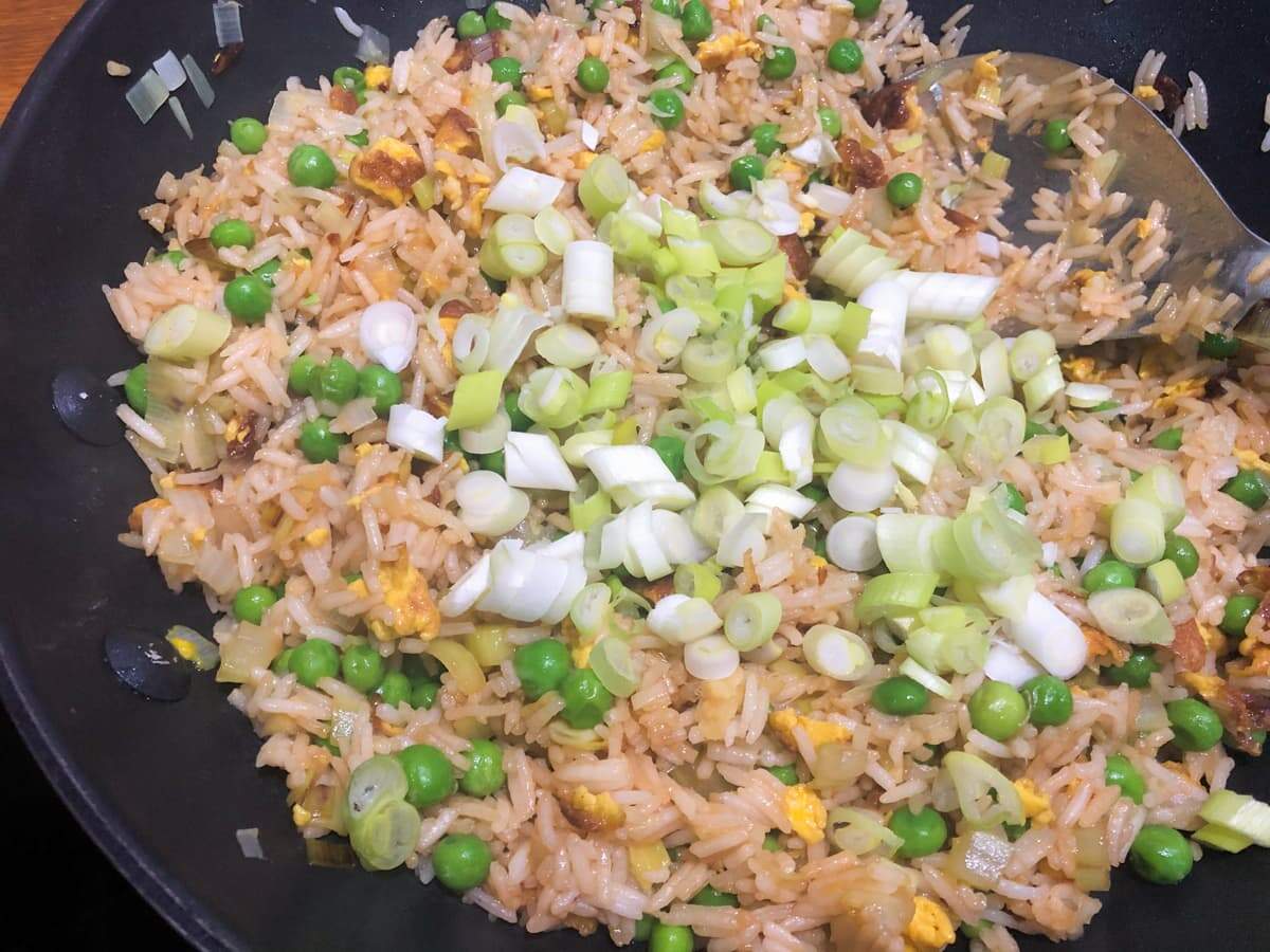 Egg fried rice adding spring onions to finish