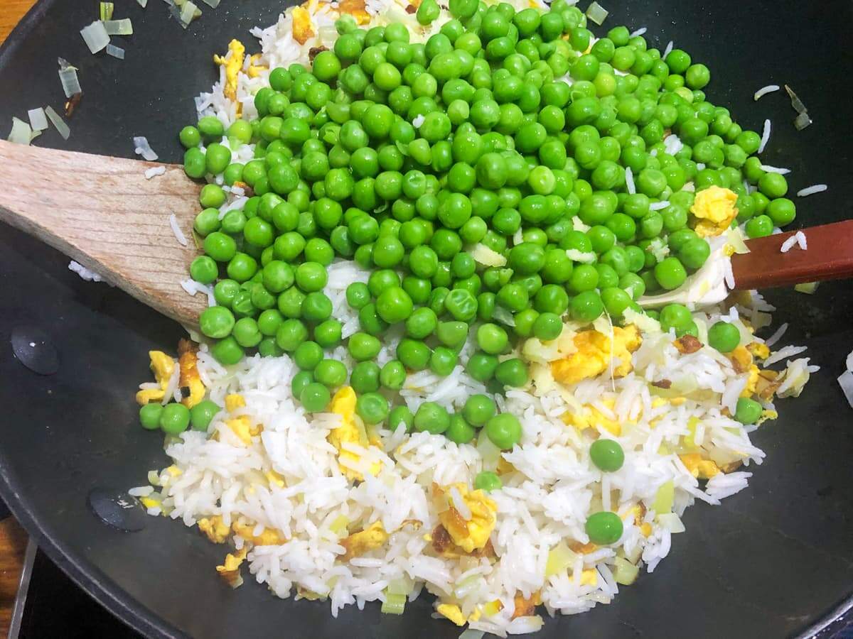 Egg fried rice and adding frozen peas and tossing.