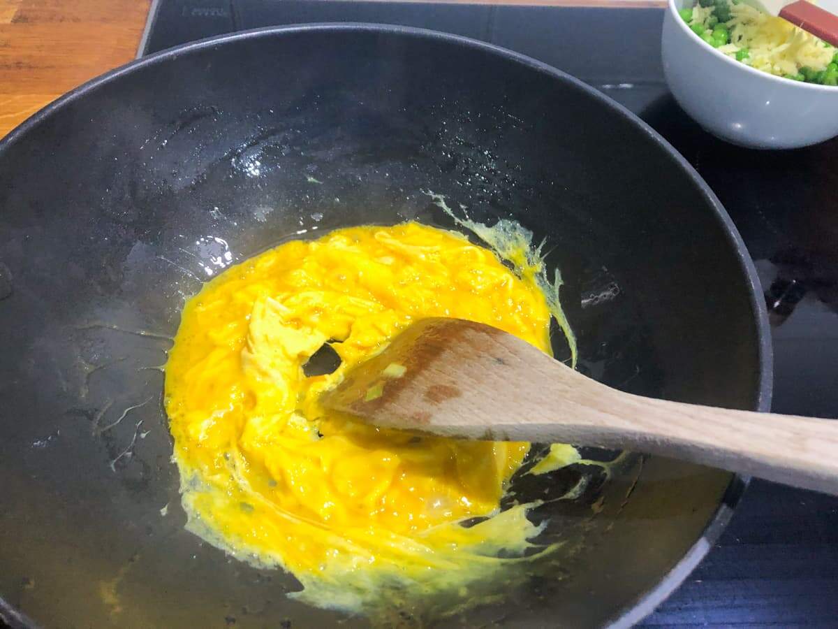 Eggs being scrambled in a pan to make egg fried rice