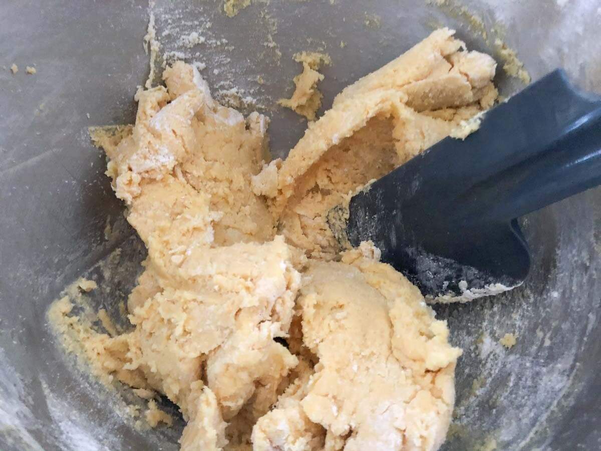 Orange biscuit dough in a metal bowl.