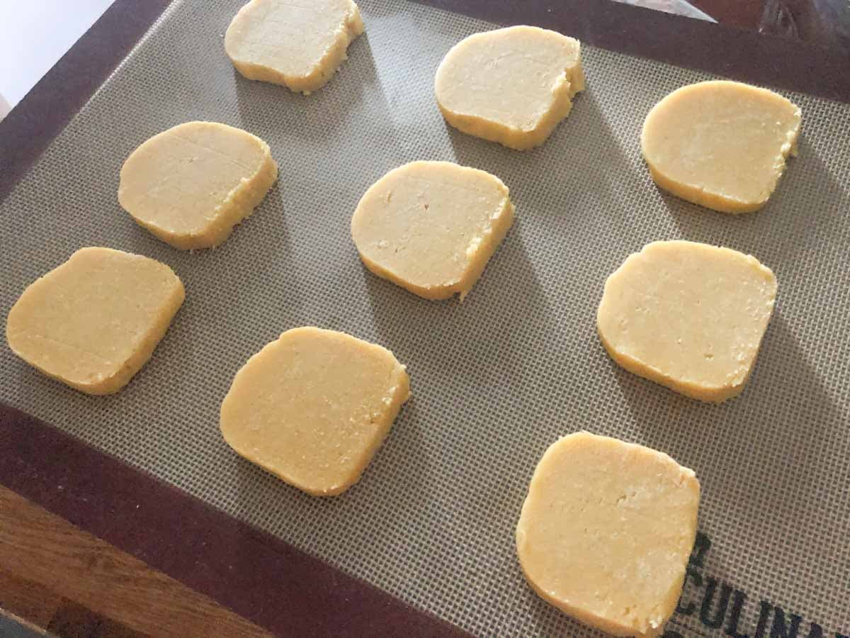 Orange biscuits on a silicone baking mat ready for the oven.