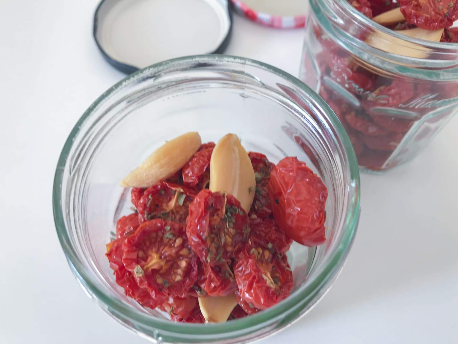 oven roasted cherry tomatoes and roasted garlic in a clean glass jar to preserve.