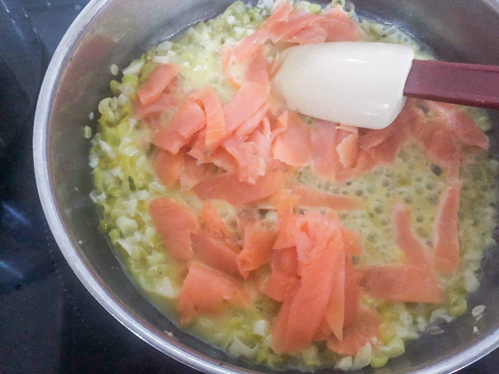 A frying pan with onions, garlic and smoked pasta