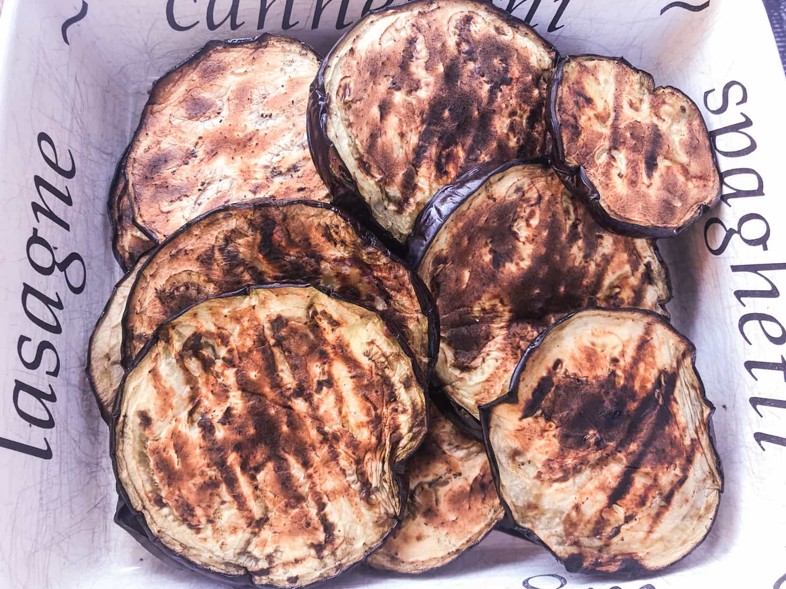 Chargrilled aubergines (eggplant) in a tray.