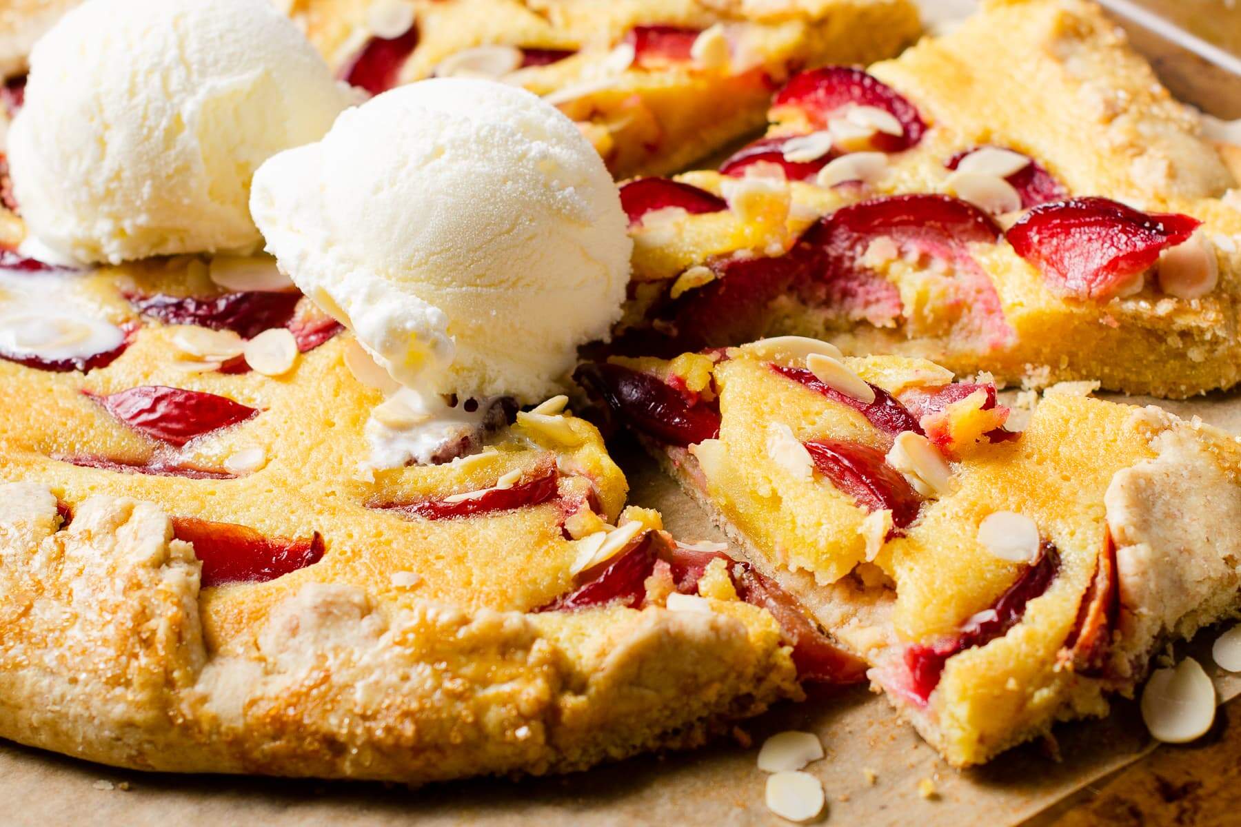 A plum and almond galette tart with 2 scoops of vanilla ice cream
