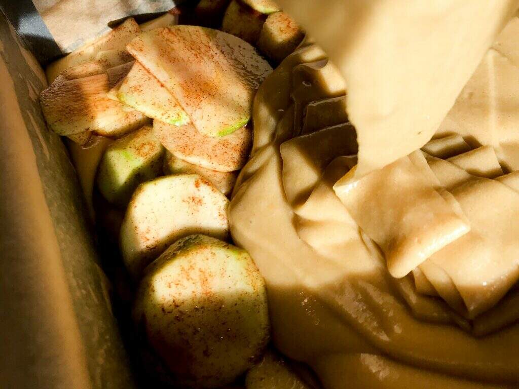 Cake batter poured over top of spiced apples