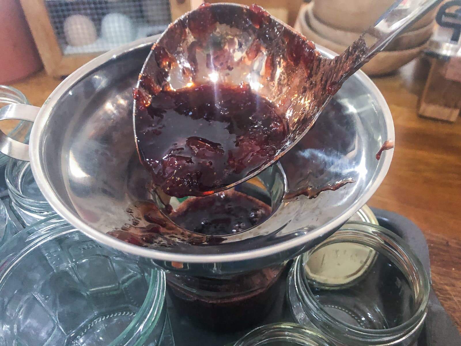 Decanting fresh homemade jam into sterilised jars.