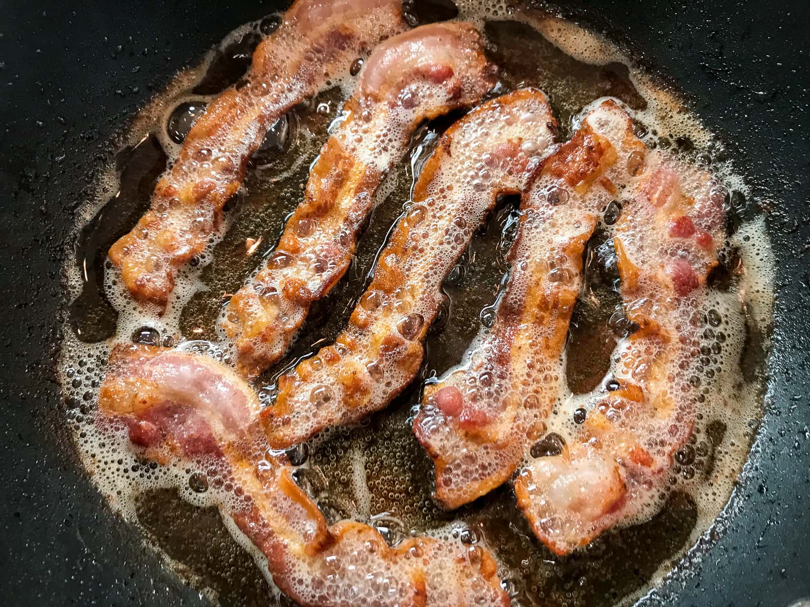 bacon frying in a pan.