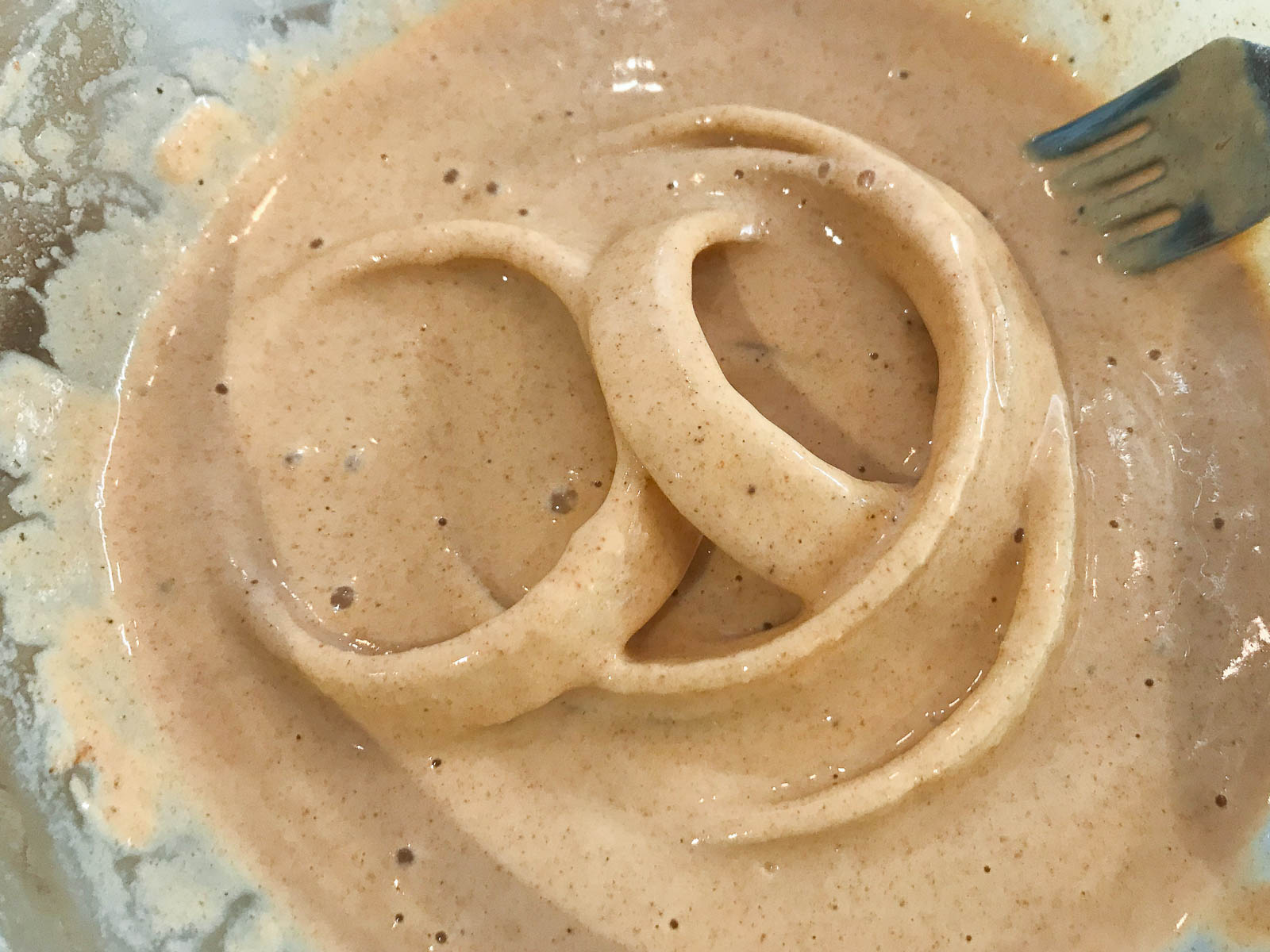 Slices of onions in a batter before being fried to make onion rings.