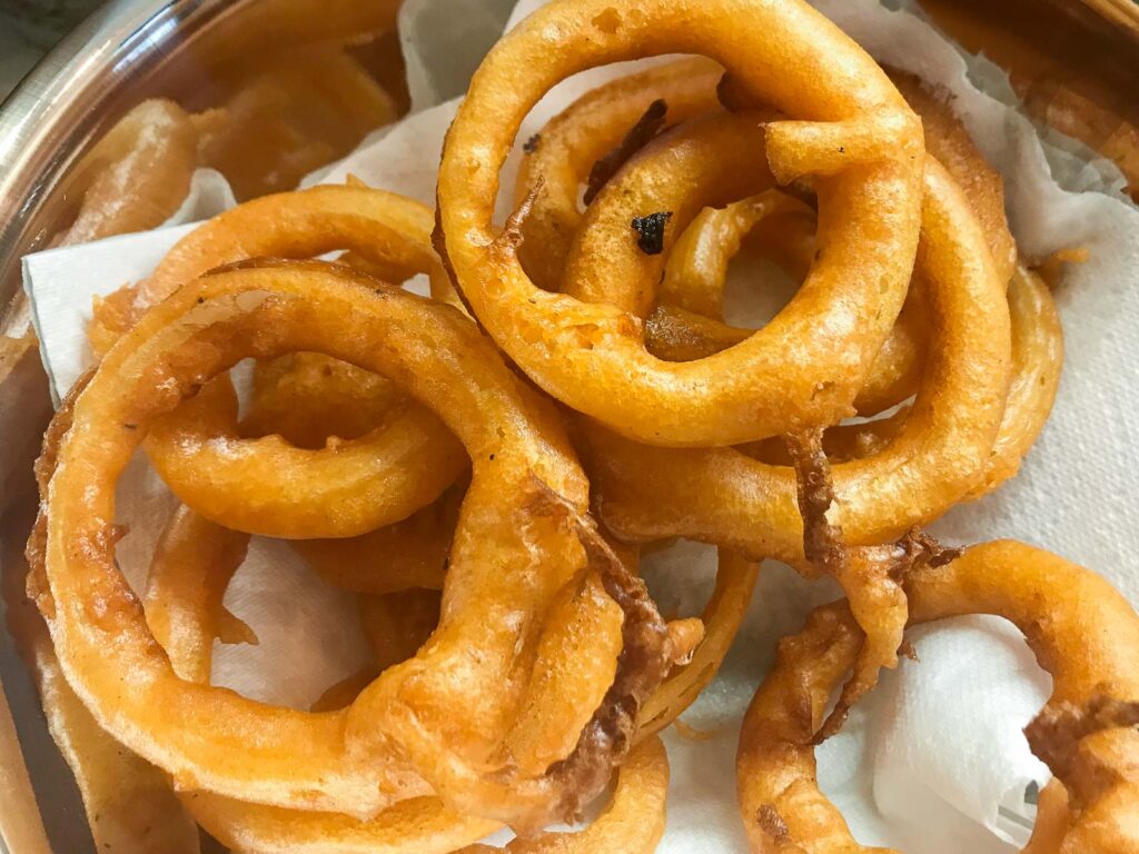 Crispy onion rings, freshly cooked and draining on kitchen paper.