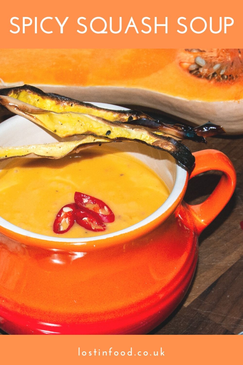Vibrant squash soup with added chillis served in an orange cauldron style bowl.