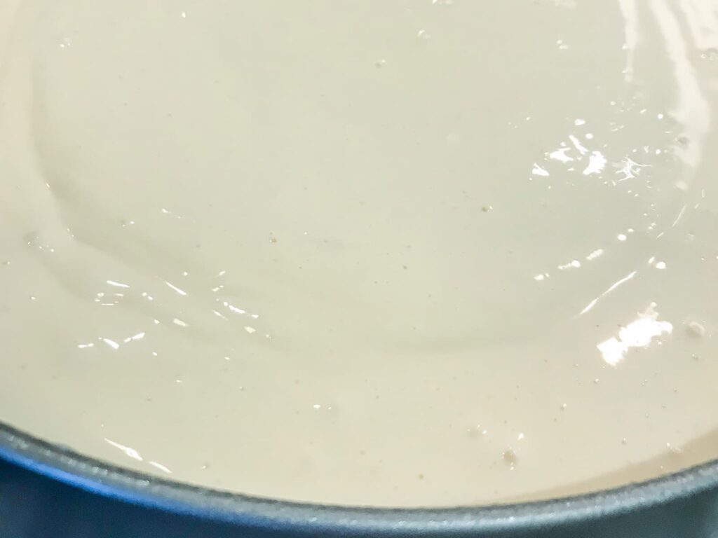 Baked vanilla cheesecake batter showing tiny air bubbles on the surface before being baked.