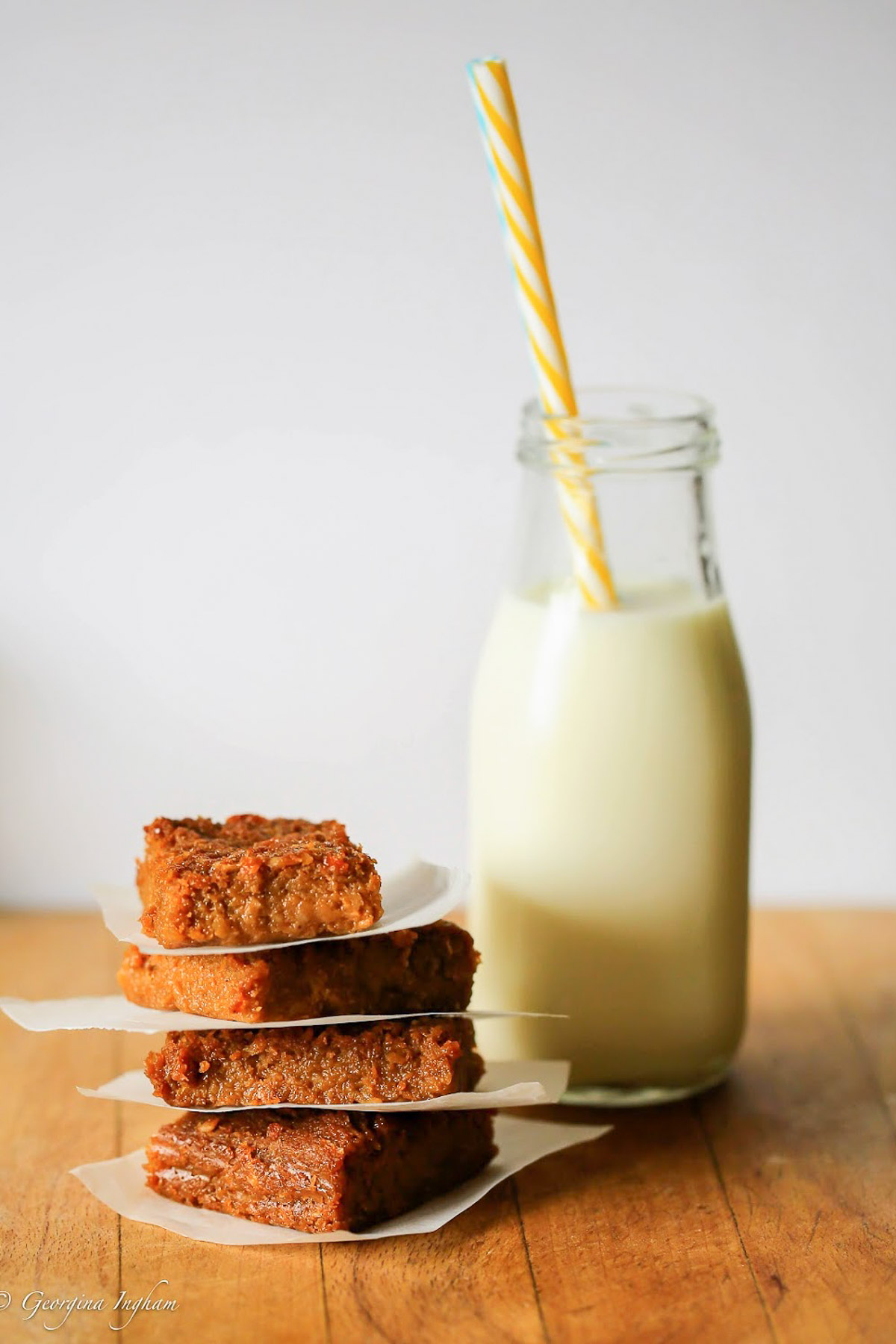 A stack of sticky gingerbread from Culinary Travels Blog with a bottle of milk.