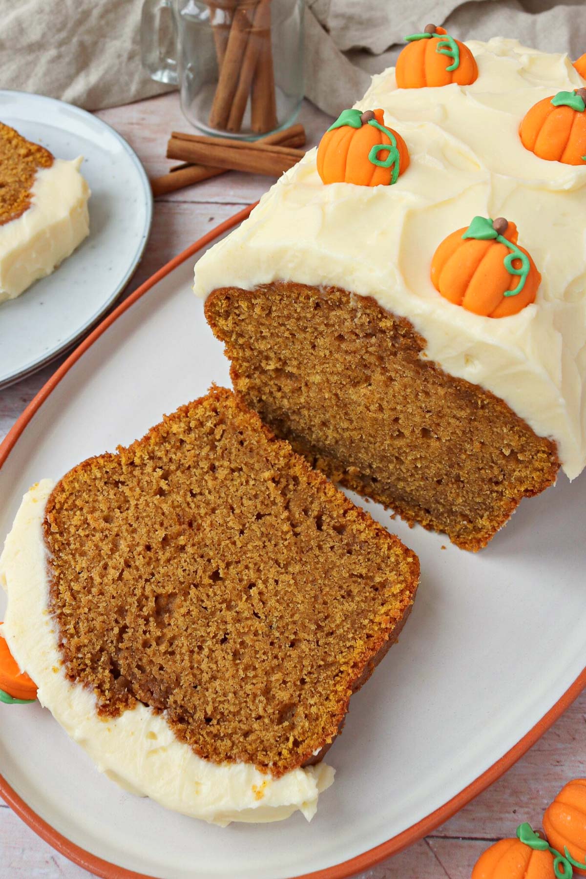 Pumpkin loaf with cream cheese frosting from The Baking Explorer decorated with candy pumpkins.