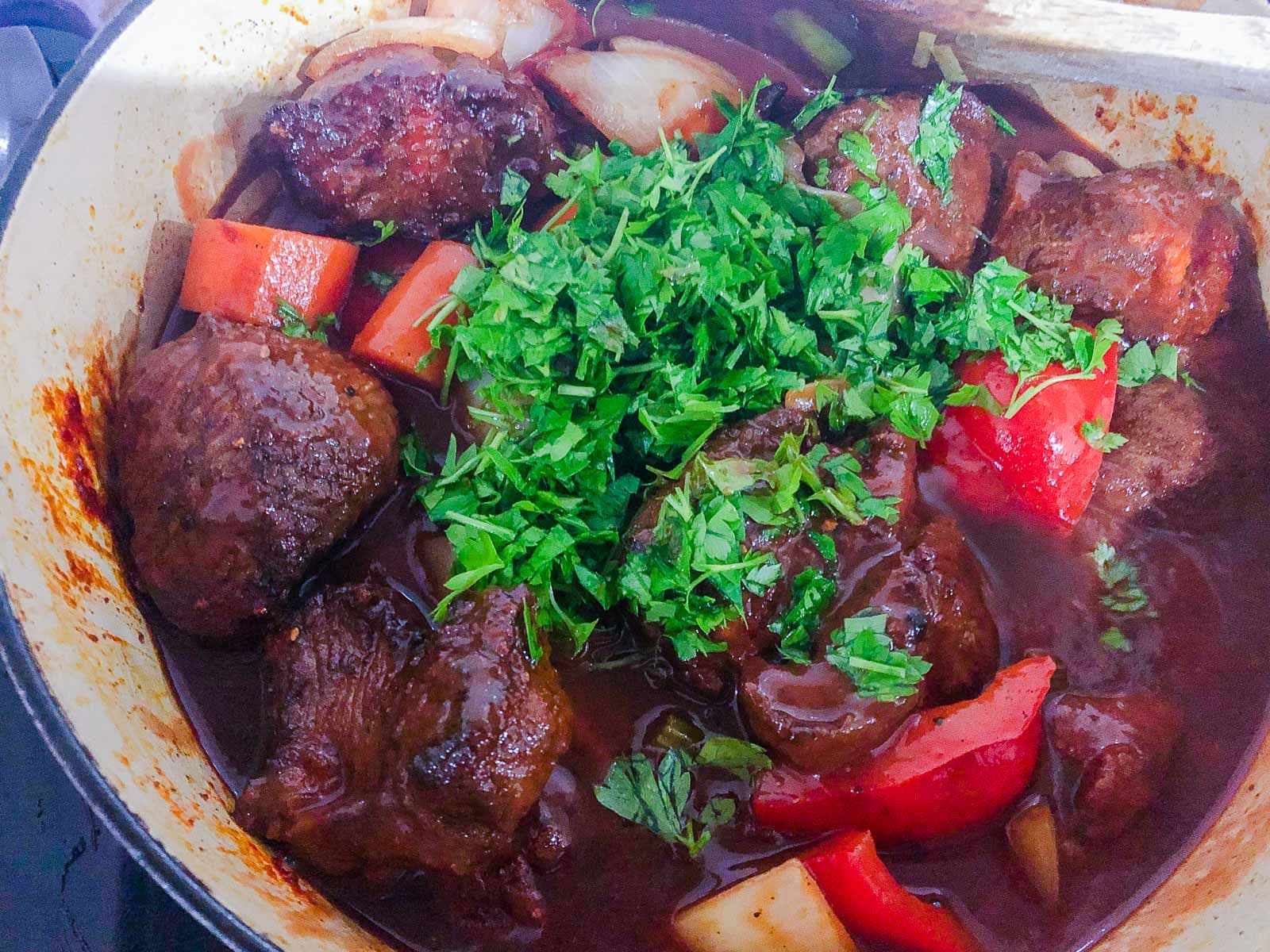 A cooked casserole of paprika beef (beef goulash) topped with fresh chopped parsley.