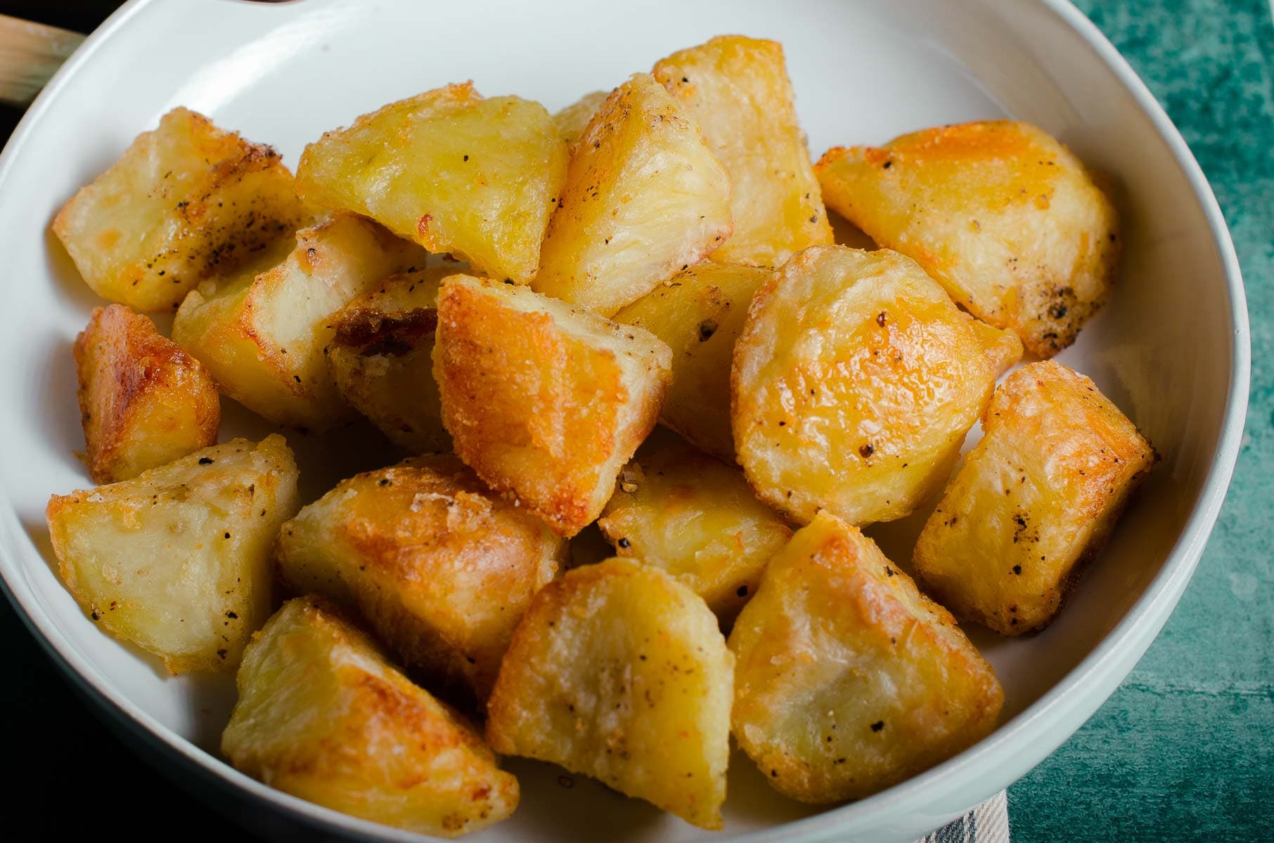 A bowl of crunchy golden roast potatoes.