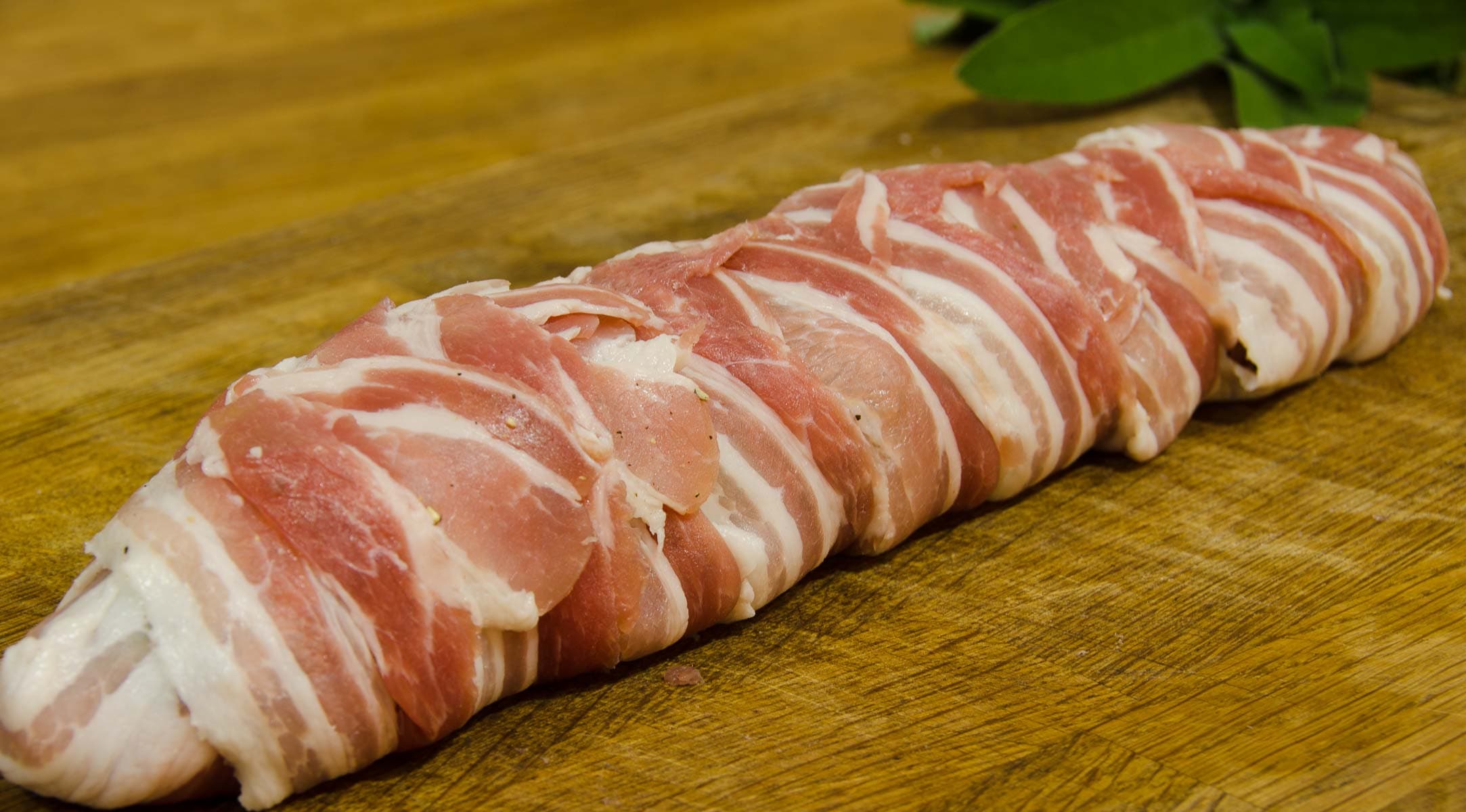 A full sized pork fillet wrapped in smoked bacon with fresh sage.