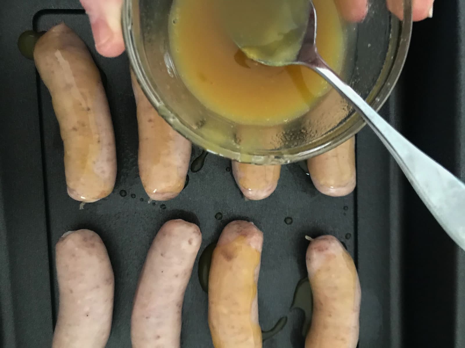 Glazing sausages with a honey and mustard dressing.