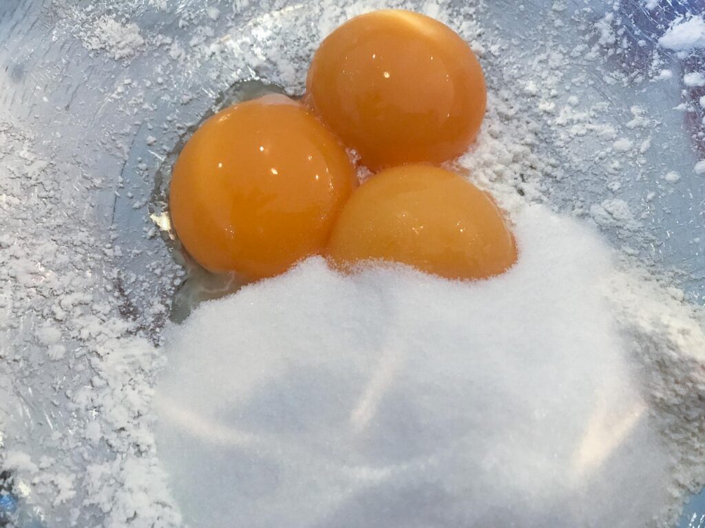 3 egg yolks with caster sugar and flour to form the basis of a homemade custard.