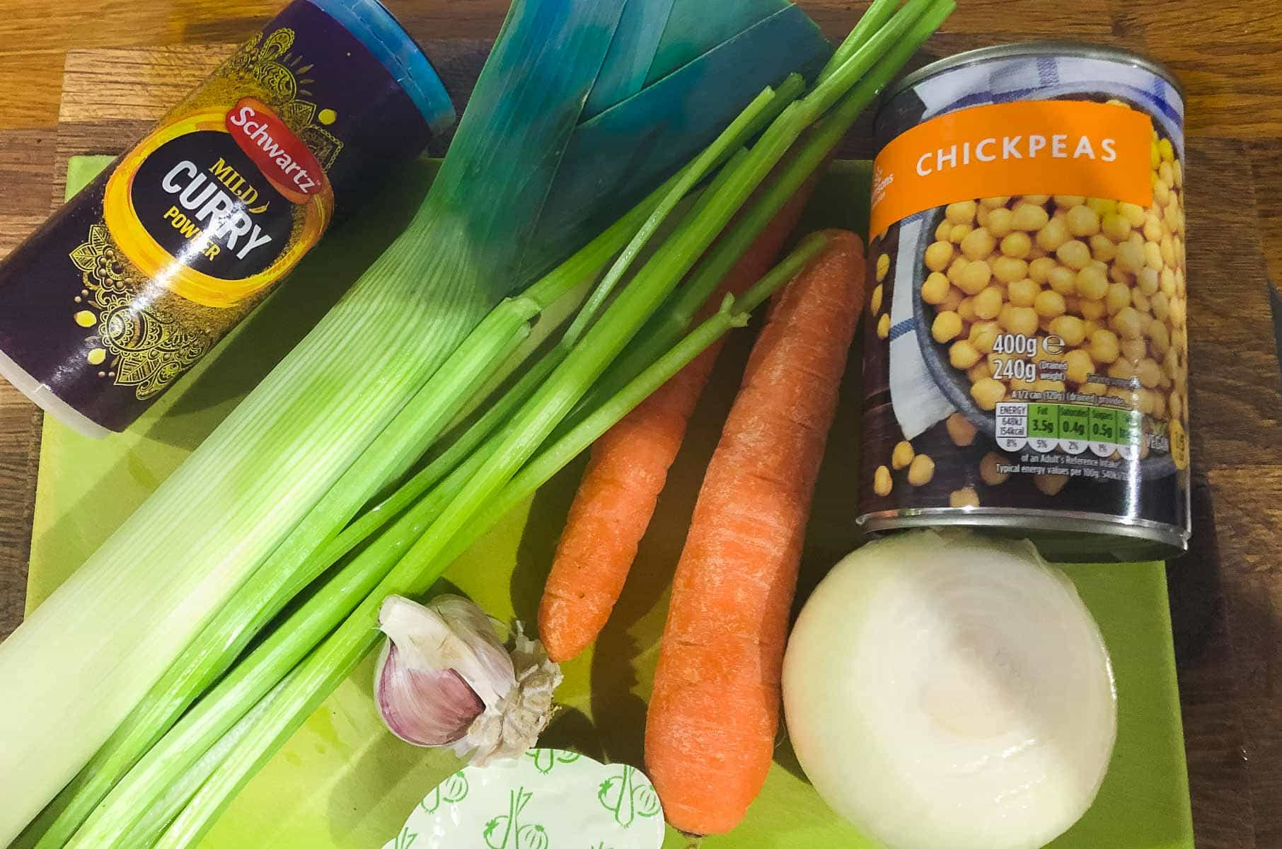 Soup ingredients laid on a wooden chopping board.