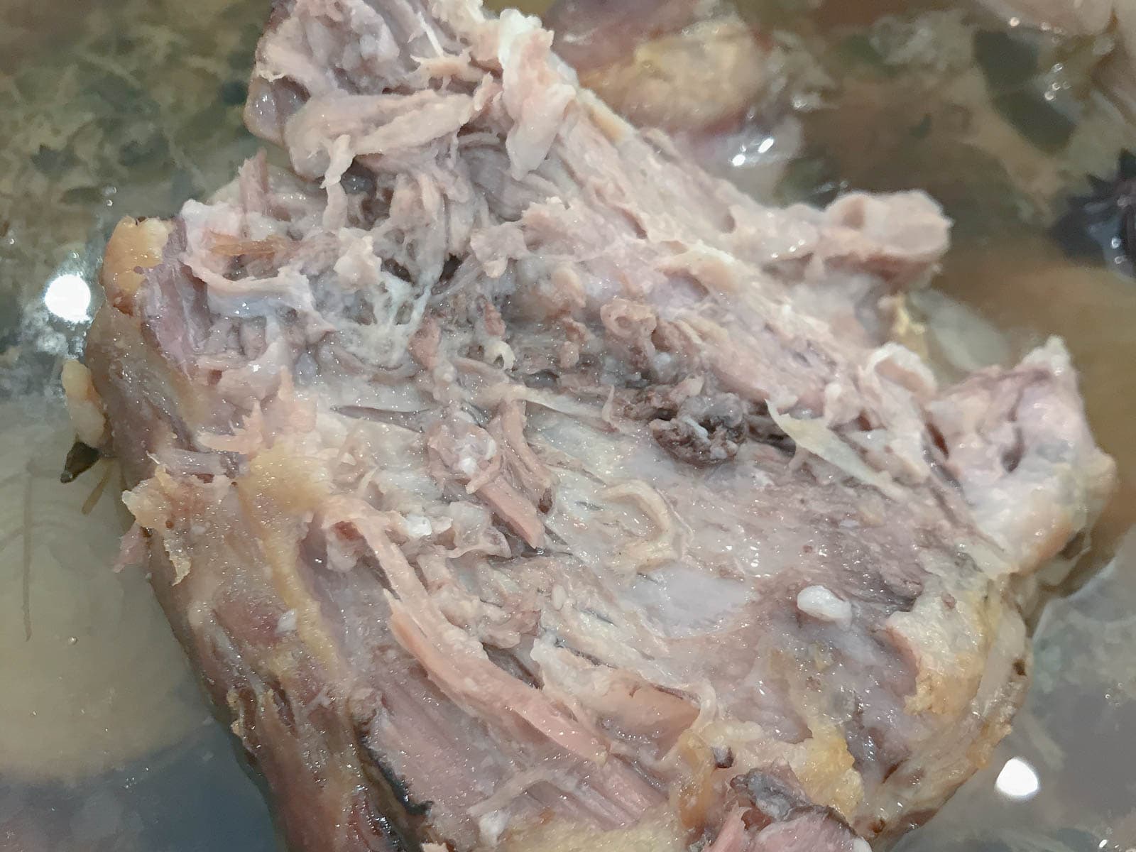 A large piece of pork shoulder cooked in a vegetable based broth