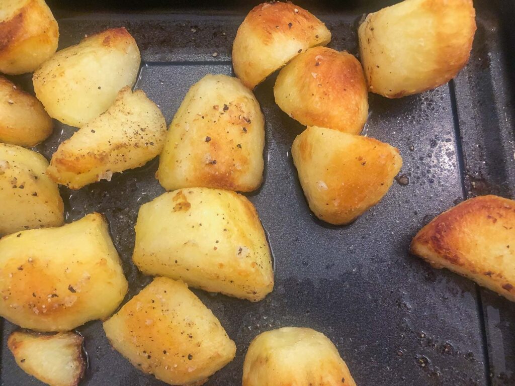 Perfectly cooked roast potatoes in a tray.