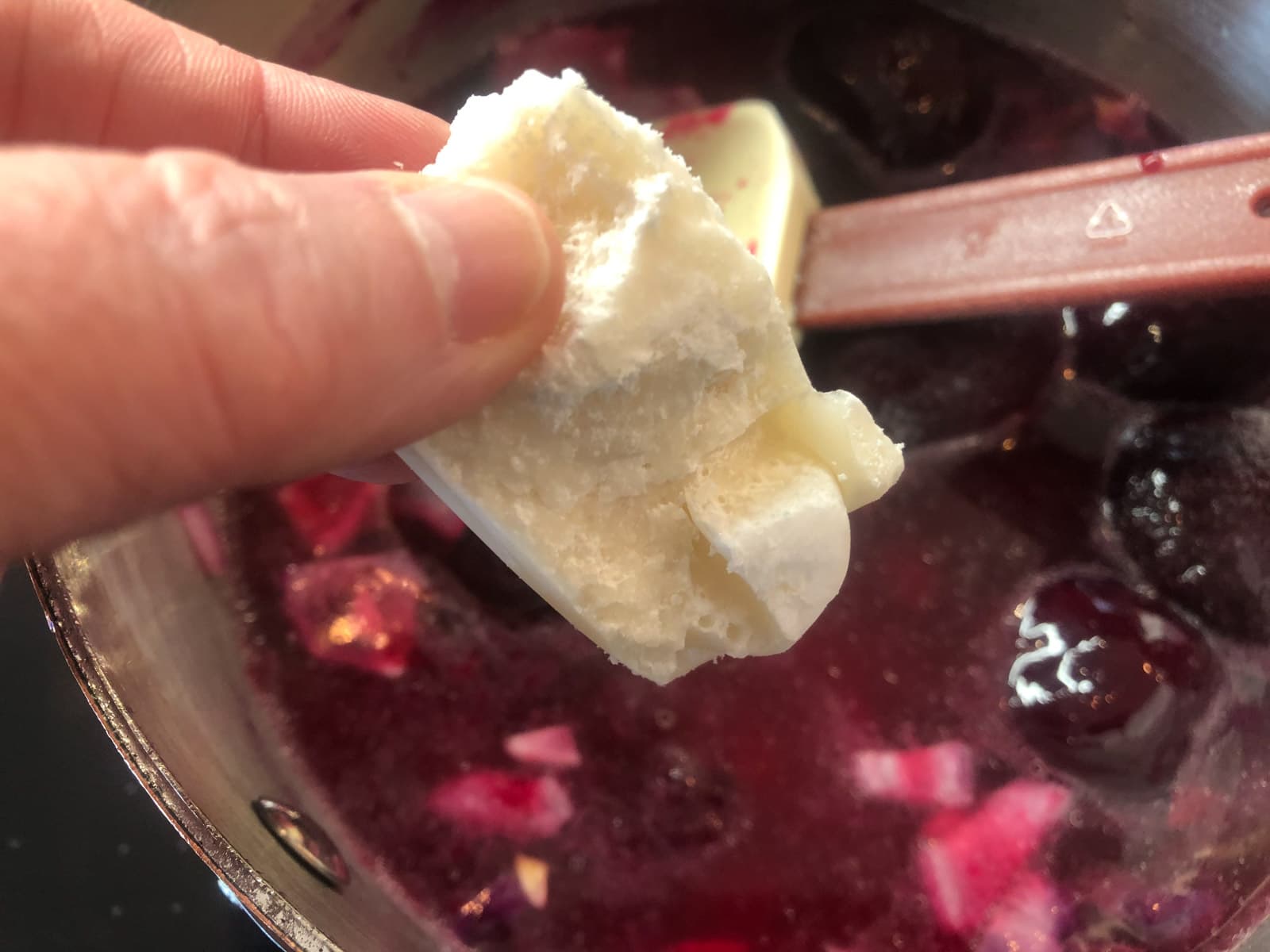 Coconut cream being added to a pan of beetroot for adding creaminess