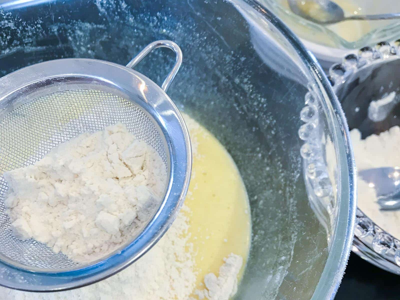 Sifting flour into a lemon madeleine batter