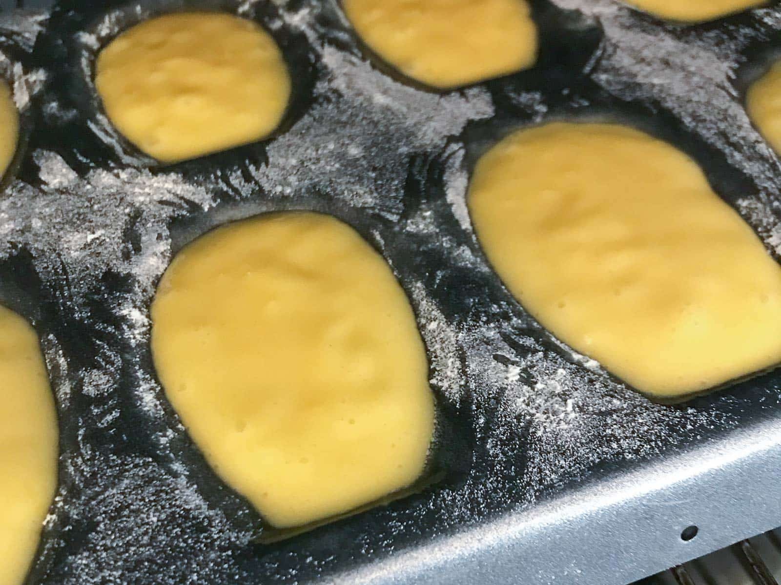 A madeleine tray with batter added ready to be baked.