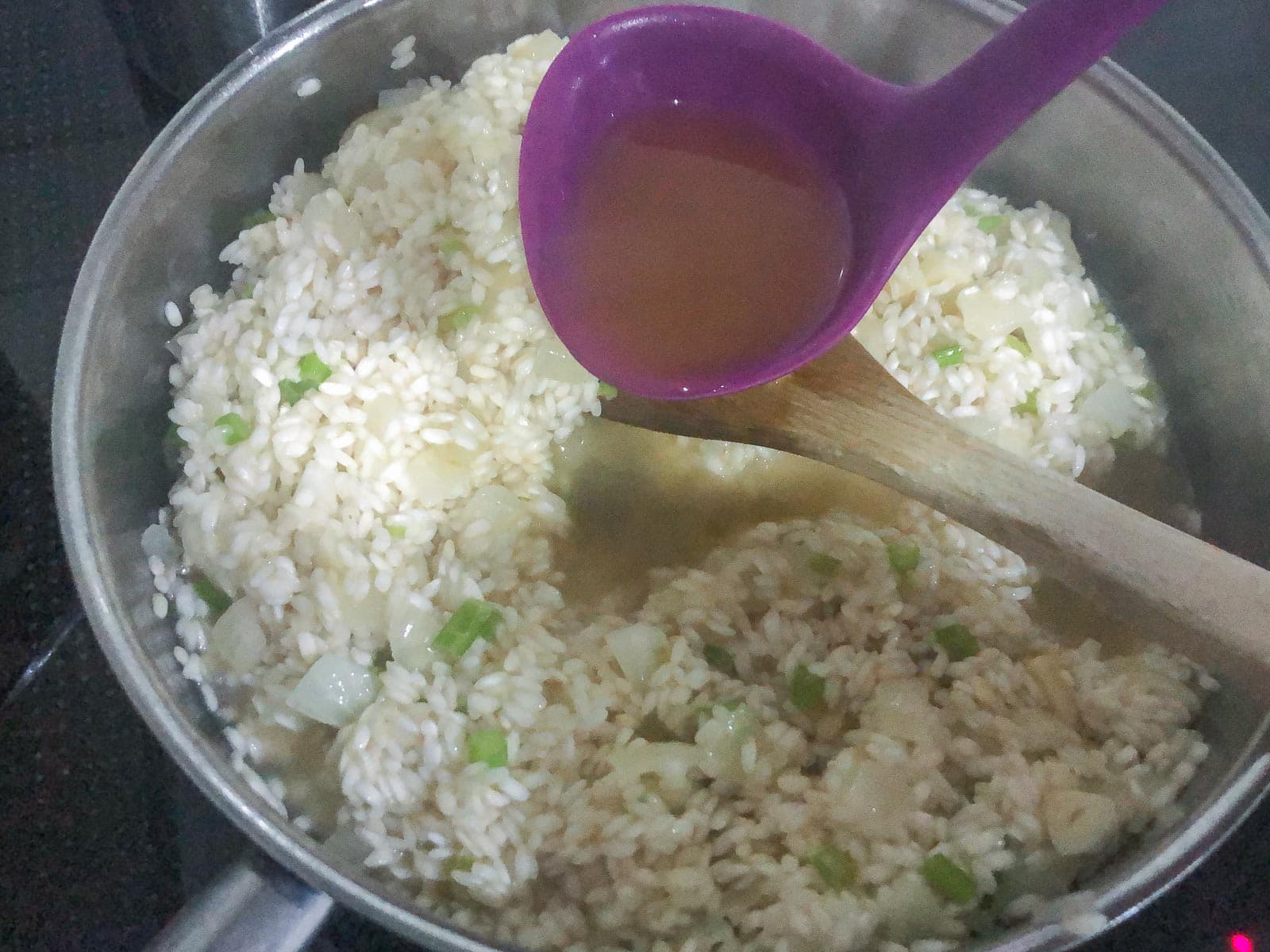 Making risotto and adding stock with a ladle