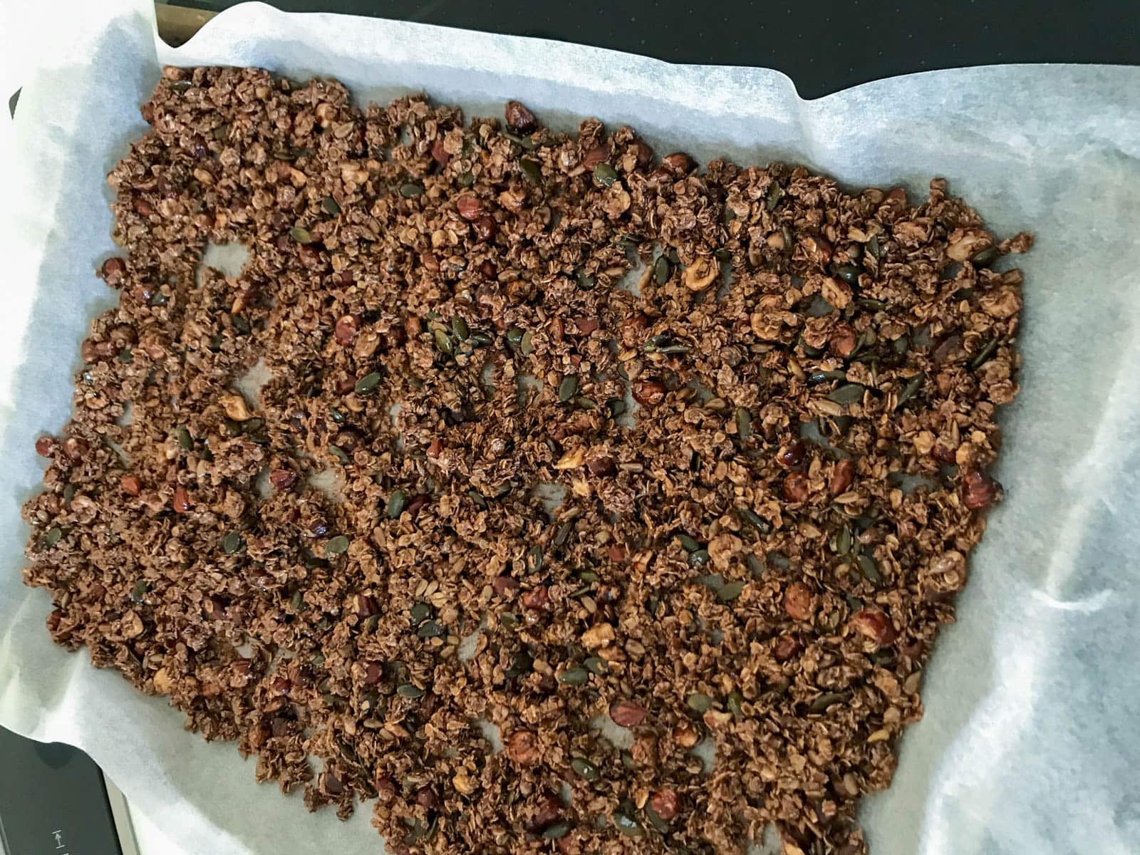 Chocolate hazelnut granola on a tray ready to bake