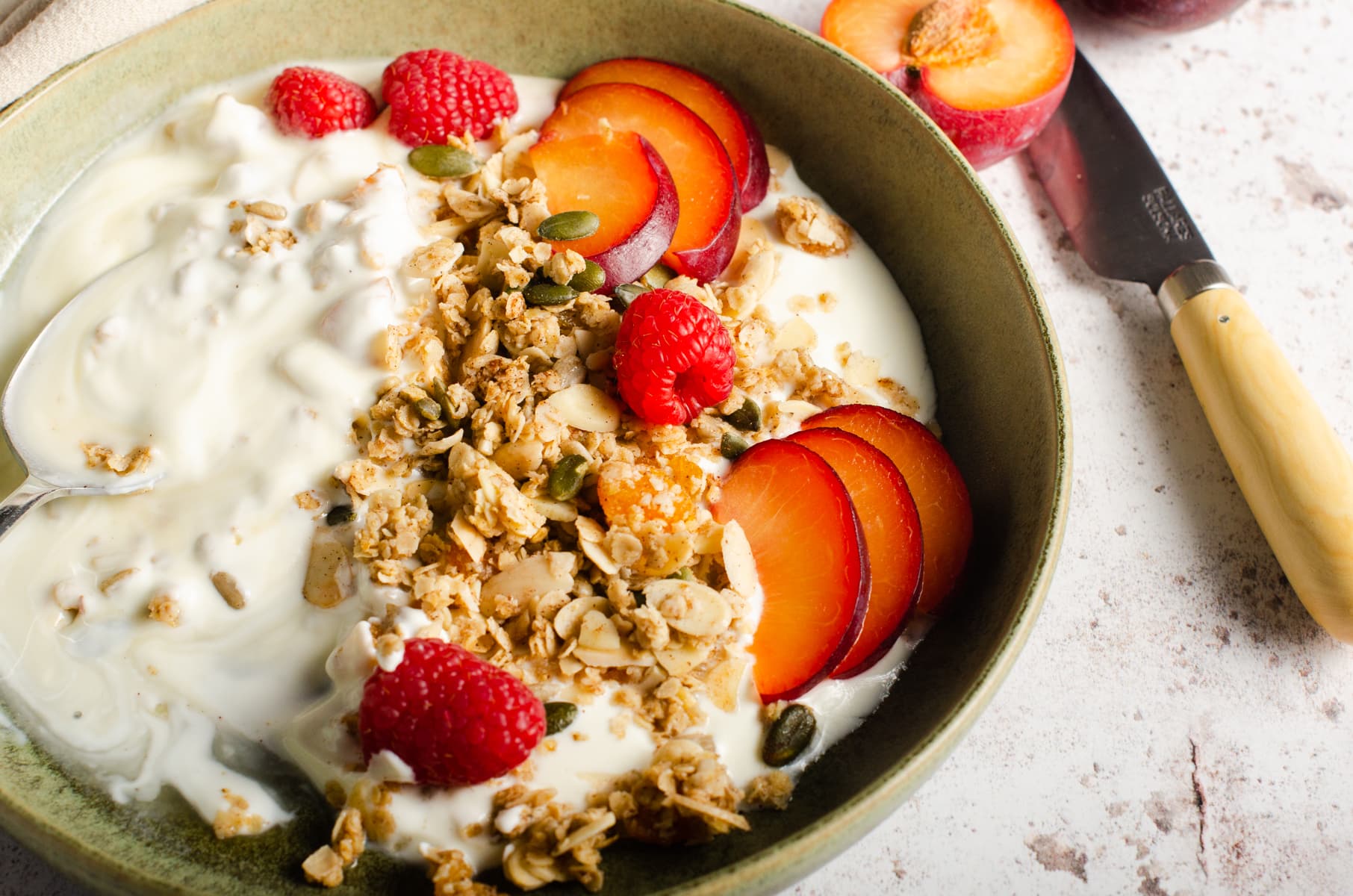 A breakfast setting of granola, yogurt and fresh fruit.