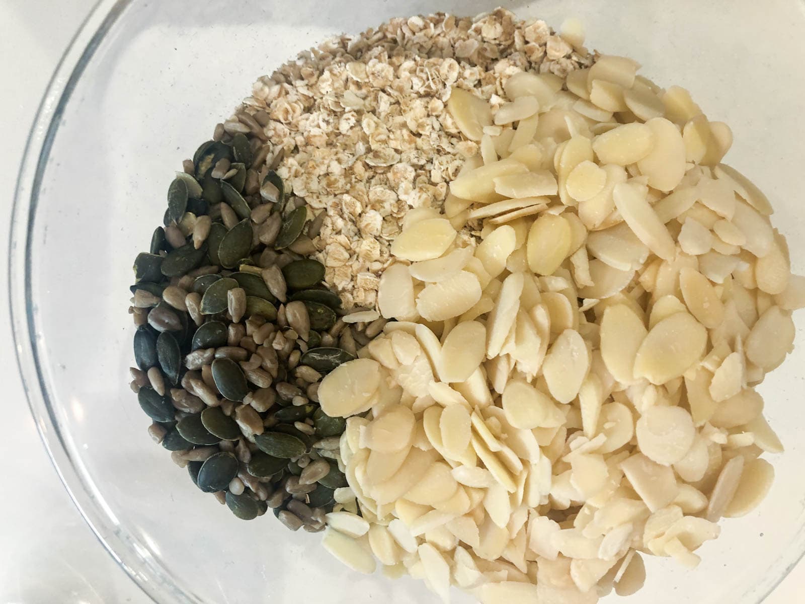 A bowl of porridge oats, sliced almonds, pumpkin and sunflower seeds.