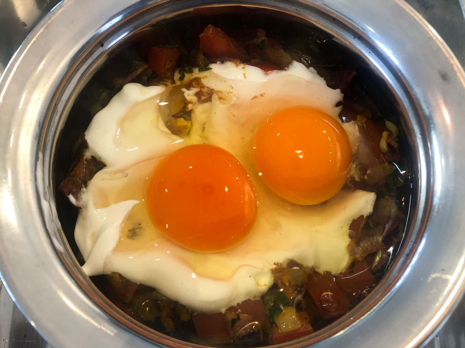 Eggs added to vegetables to be baked.